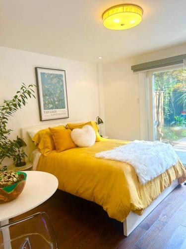 a bedroom with a yellow bed and a table at Central Toronto in Toronto