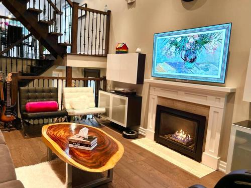 a living room with a fireplace with a tv above it at Central Toronto in Toronto