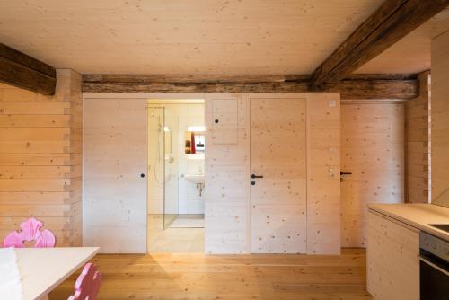 a kitchen with wooden walls and wooden floors at Alfenalm - Ferienwohnungen am Berg - Giatla Haus in Innervillgraten