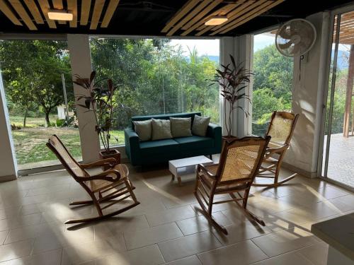 sala de estar con mecedoras y sofá en Villa San Martín, en Sopetrán