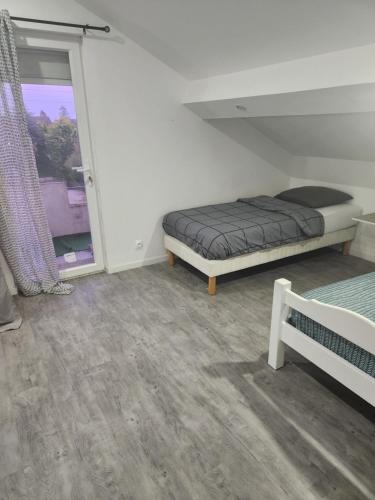 a bedroom with a bed and a window at la Colombière in Longvic