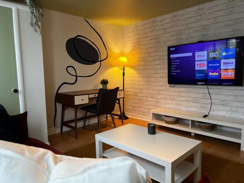 a living room with a desk and a tv on a wall at Stylish 1-BDRM Prime Location, Unit 2 in Halifax