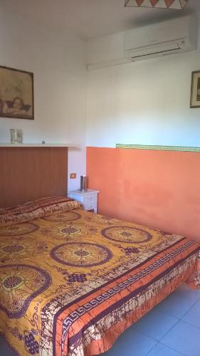 sypialnia z łóżkiem z kolorową narzutą w obiekcie Residence La Colombaia 1. 5/6 Beds w mieście Porto Azzurro