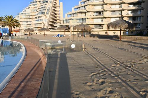 a sandy beach with a building and a resort at San Alfonso del Mar Ideal in Mirasol