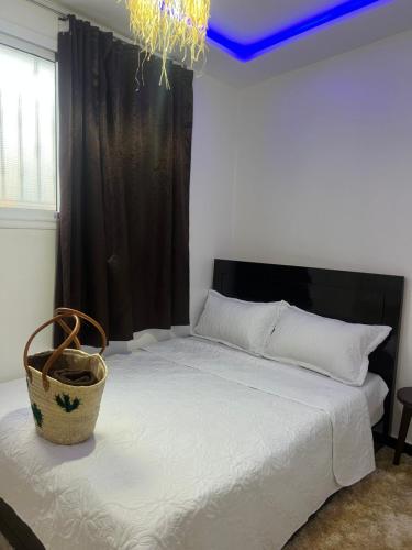a bedroom with a bed with a basket on it at Arinas Surf Hostel in Taghazout