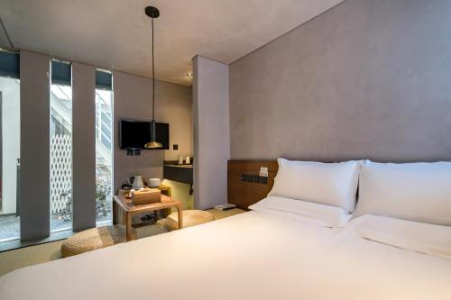 a bedroom with a large white bed and a window at 北京重构空间酒店天安门王府井店 in Beijing