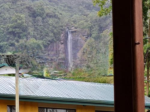 a waterfall on the side of a mountain at sasru holiday home in Nuwara Eliya