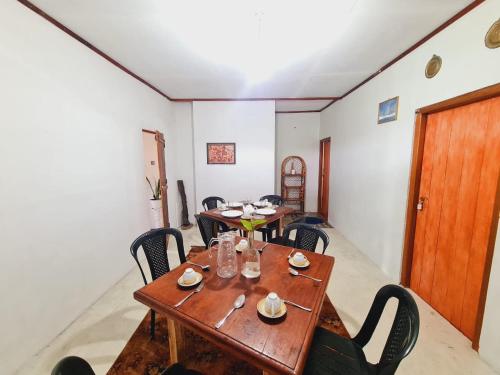 a dining room with wooden tables and chairs at sasru holiday home in Nuwara Eliya