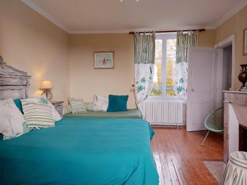 a bedroom with a bed with blue sheets and a window at Maison de caractère avec piscine chauffée, étang privé et proche forêt, à 90 min de Paris - FR-1-581-48 in La Chapelle-Fortin