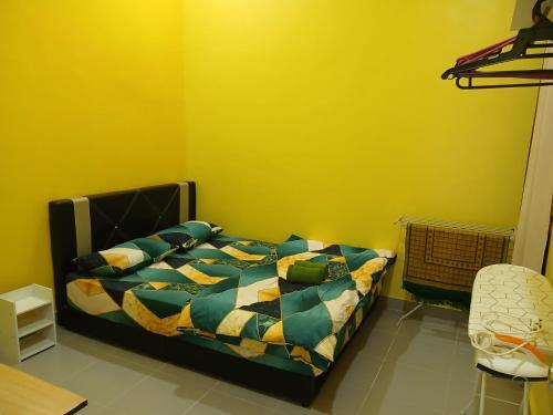 a bedroom with a bed and a yellow wall at Hill View Paka Homestay in Paka
