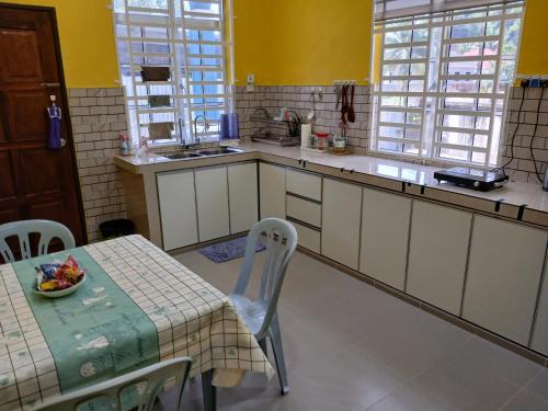 a kitchen with a table with a bowl of fruit on it at Hill View Paka Homestay in Paka