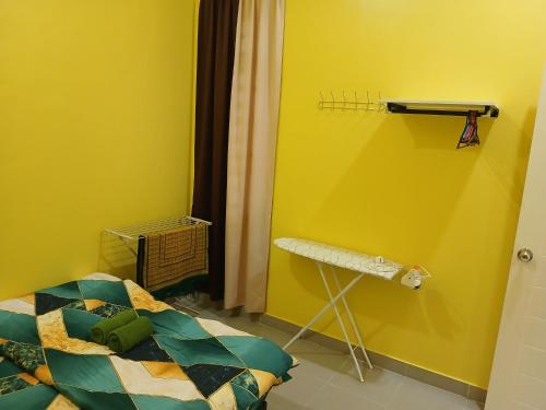 a bedroom with a bed and a yellow wall at Hill View Paka Homestay in Paka