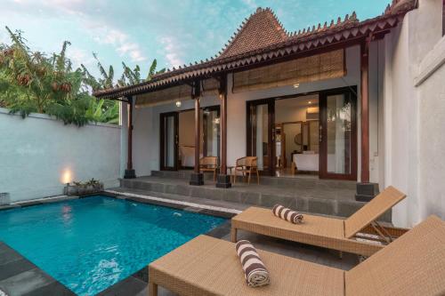 a villa with a swimming pool and a house at Sakya Villa Canggu By Bali Cabin in Canggu