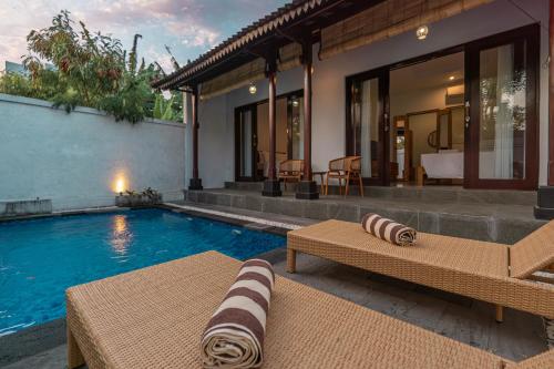 a villa with a swimming pool and a house at Sakya Villa Canggu By Bali Cabin in Canggu