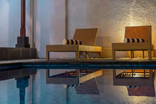 two chairs sitting next to a swimming pool at Sakya Villa Canggu By Bali Cabin in Canggu