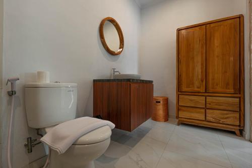 a bathroom with a toilet and a sink and a mirror at Sakya Villa Canggu By Bali Cabin in Canggu
