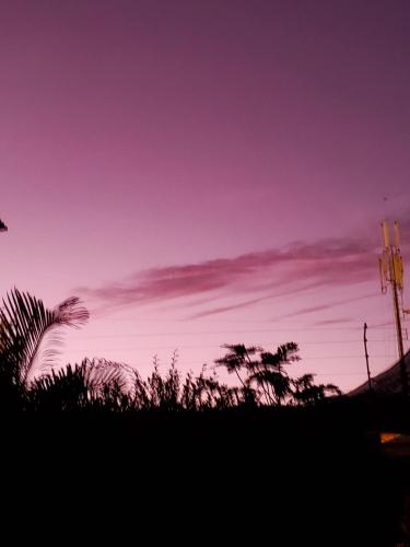 a silhouette of a sunset with trees in the foreground at HOSTAL SAN MARINO in Manta