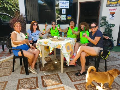 a group of people sitting around a table with drinks at HOSTAL SAN MARINO in Manta