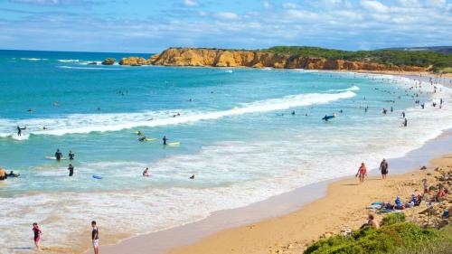 a group of people in the water at a beach at Absolute Beachfront Retreat on The Esplanade in Torquay