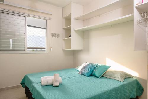 a bedroom with a bed with two towels on it at Helbor Atlantis by Doce Lar de Bertioga in Bertioga