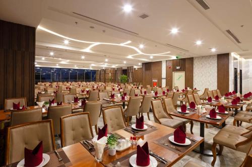 a restaurant with tables and chairs in a room at Vesna Hotel Nha Trang in Nha Trang