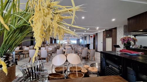 a restaurant with tables and chairs in a room at Vesna Hotel Nha Trang in Nha Trang