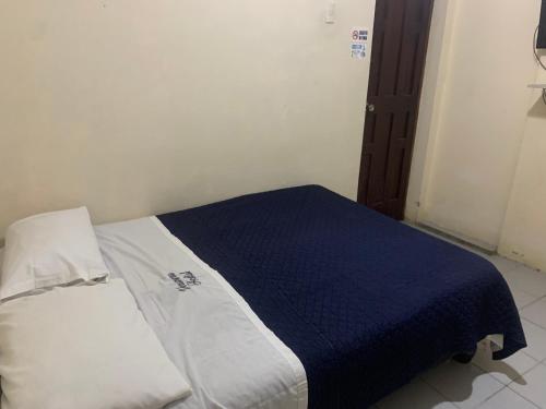 a bedroom with a bed with a blue blanket at Veranera Hostal in Manta