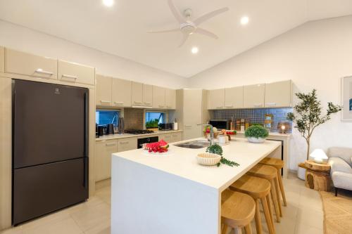 a kitchen with a large island with a counter top at Private Luxury Haven with SUV Hire, Pool, Near Marina in Trinity Beach