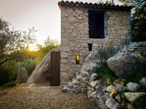 - un bâtiment en pierre avec une fenêtre et un mur en pierre dans l'établissement Remote cottage with valley views, à Buis-les-Baronnies