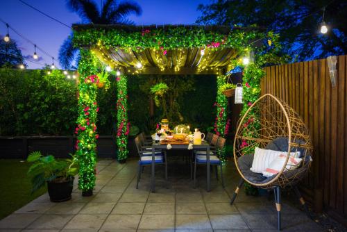 a garden with a table and a pergola with christmas lights at Private Luxury Haven with SUV Hire, Pool, Near Marina in Trinity Beach