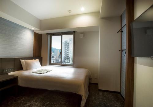 a hotel room with a bed and a large window at Hotel and Spa Gift TAKAYAMA in Takayama