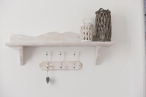 a wooden shelf with hooks on a white wall at Primo Piano Suites in Rome