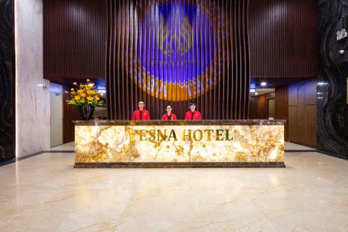 three men standing behind a hotel sign in a lobby at Vesna Hotel Nha Trang in Nha Trang