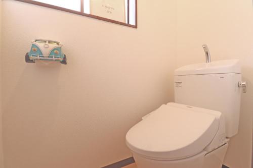 a bathroom with a toilet with a toy car on the wall at Kurasako Onsen Sakura in Minamioguni