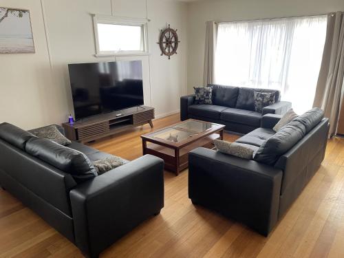 a living room with two couches and a tv at The Sabble Shak in Capel Sound