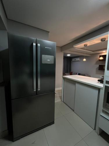 a kitchen with a black refrigerator in a room at Apartamento Central 2 Quartos c Garagem in Pelotas