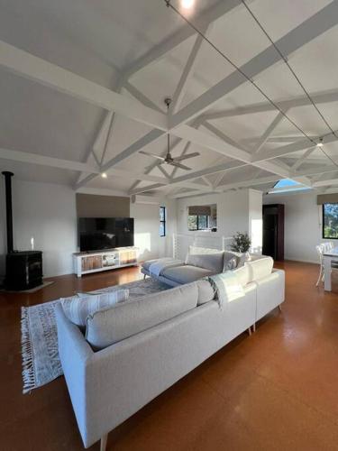 a living room with a couch and a ceiling at Boutique Coastal Beach House Cowes Phillip Island Sleeps 8 in Cowes