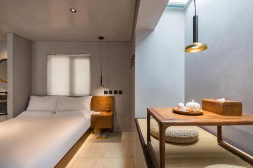 a bedroom with a bed and a table at 北京重构空间酒店天安门王府井店 in Beijing