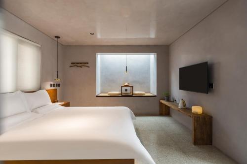 a bedroom with a large white bed and a window at 北京重构空间酒店天安门王府井店 in Beijing