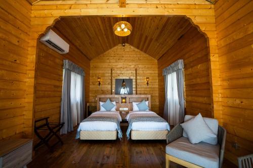 a bedroom with two beds in a wooden cabin at Sutera at Mantanani Island Resort & Spa in Mantanani Island 