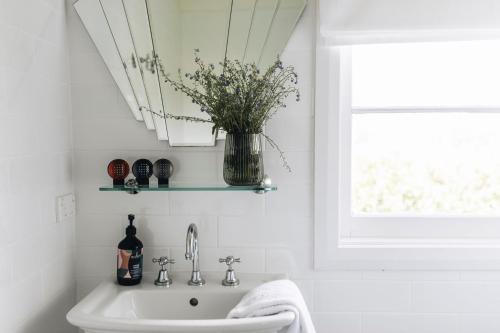 a bathroom with a sink and a vase of flowers at Daisy Hill Southern Highlands in Moss Vale