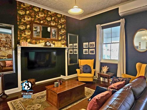 a living room with a couch and a television at 3 BR Little Addis Cottage in Historic Kalgoorlie in Kalgoorlie