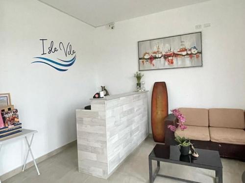 a living room with a couch and a sign on the wall at Hotel Isla Vela Paracas in Paracas