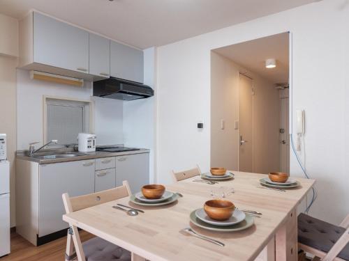 a kitchen with a table and chairs with bowls on it at Tokyo Stay Akasaka in Tokyo