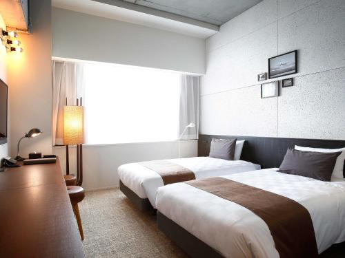 Postel nebo postele na pokoji v ubytování Kawasaki King Skyfront Tokyu REI Hotel
