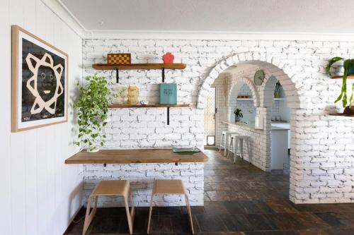 a room with a table and two chairs and a brick wall at Caba Bliss - Walk to Cabarita Beach! in Cabarita Beach