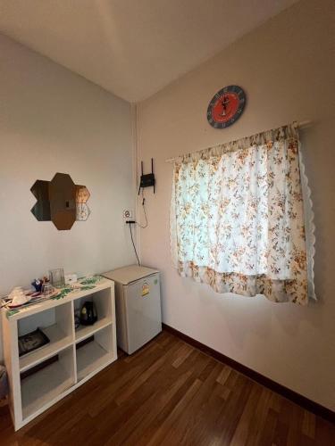 a room with a window with a dresser and a table at บ้านทอนบีช รีสอร์ท in Ban Thon