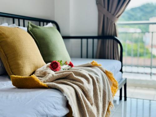 a bed with a blanket and two roses on it at New The Sun Homestay at Sg Nibong nearby Queensbay or PISA or FTZ Bayan Lepas HENG in Bayan Lepas