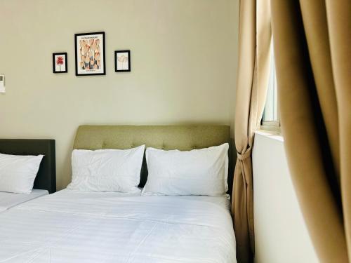 a bed with white sheets and pillows in a bedroom at New The Sun Homestay at Sg Nibong nearby Queensbay or PISA or FTZ Bayan Lepas HENG in Bayan Lepas