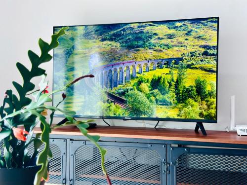 a flat screen tv on top of a entertainment center at New The Sun Homestay at Sg Nibong nearby Queensbay or PISA or FTZ Bayan Lepas HENG in Bayan Lepas